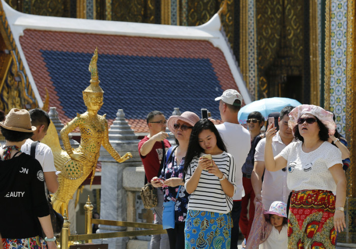 Ein chinesische Touristengruppe auf Besichtigungstour im Großen Palast in Bangkok. Foto: epa/Narong Sangnak