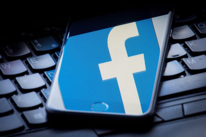 Das Facebook-Logo wird auf einem Smartphone gespiegelt, das auf einer Tastatur liegt. Foto: Dominic Lipinski/Pa Wire/dpa