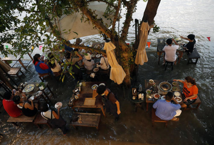 Das Hochwasser beschert dem „Chaopraya Antique Cafe“ großen Zulauf: Denn gespeist wird hier mitten im Wasser. Foto: epa/Rungroj Yongrit