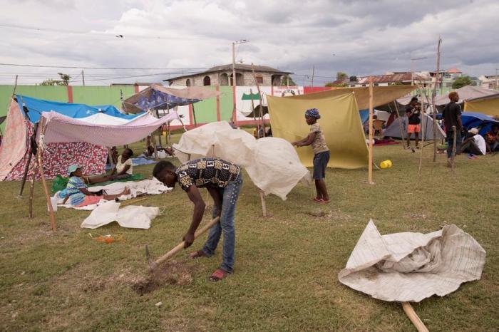 Menschengruppen organisieren sich in Les Cayes in einem behelfsmäßigen Lager, als die Regenfälle des tropischen Tiefs Grace eintreffen. Foto: epa/Orlando Barria