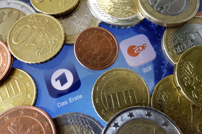 Euromünzen liegen neben den Logos der Apps von ARD und ZDF. Das Bundesverfassungsgericht verkündet an diesem Donnerstag seine Entscheidung über Verfassungsbeschwerden der öffentlich-rechtlichen Sender ARD, ZDF und Deuts... Foto: Soeren Stache/dpa