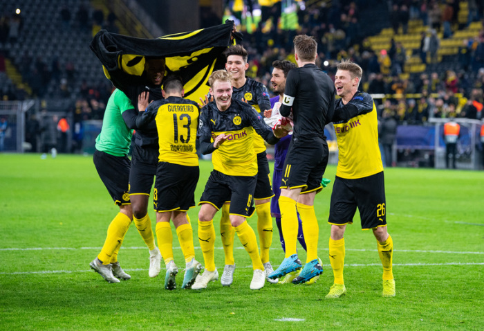 Die Dortmunder Spieler feiern und tanzen nach dem Spiel vor der Fans. Foto: Guido Kirchner/Dpa