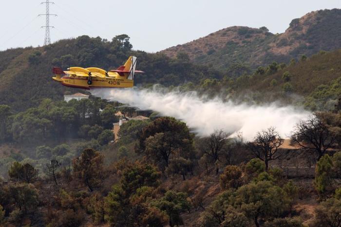 Ein Wasserflugzeug schüttet Wasser in den Waldbrand, der in der Sierra Bermeja in Málaga ausgebrochen ist. Foto: epa/Daniel Perez