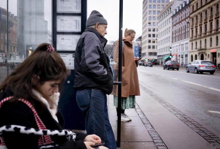 Reisende warten an einer Bushaltestelle in Kopenhagen. Foto: epa/Liselotte Sabroe