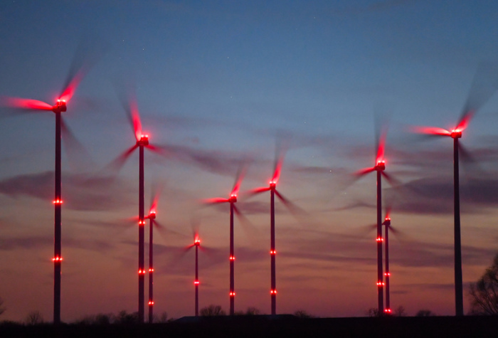 Rote Positionslichter leuchten in der Dämmerung an Windrädern im Windenergiepark «Odervorland» im Landkreis Oder-Spree. Foto: Patrick Pleul/Dpa-zentralbild/dpa