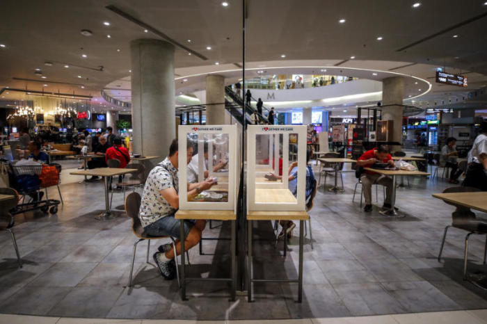 Food-Courts in Corona-Zeiten: Um die soziale Distanz zu achten, wird in den Kantinen in Bangkoker Shopping Malls vor Plexiglas-Wänden oder an Einzeltischen gespeist. Foto: epa/Diego Azubel