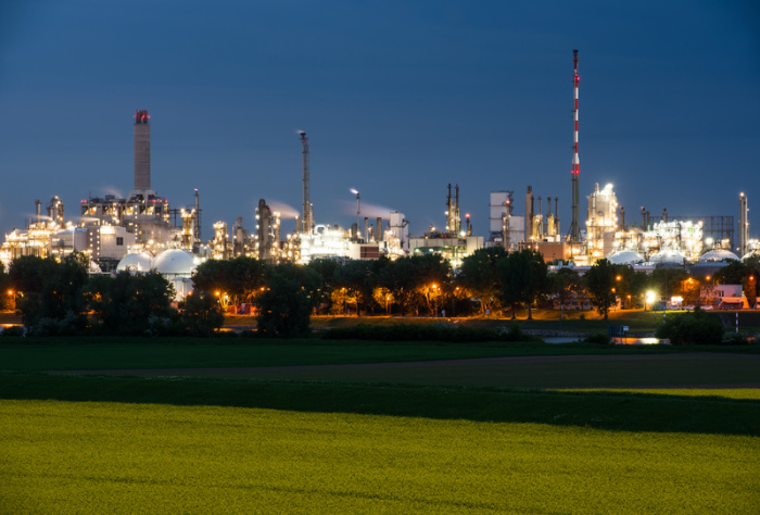 Der Produktionsstandort des Chemie-Unternehmens BASF ist zur «Blauen Stunde» hell erleuchtet. Im Vordergrund blüht ein Rapsfeld. Foto: Andreas Arnold/Dpa