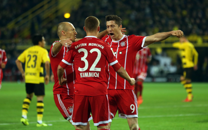 Arjen Robben (l), Joshua Kimmich und Robert Lewandowski (r) von München bejubeln das 0:2 gegen Dortmund. Foto: Ina Fassbender/dpa