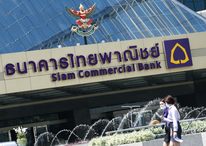 Passanten vor der Zentrale der Siam Commercial Bank in Bangkok. Foto: epa/Narong Sangnak