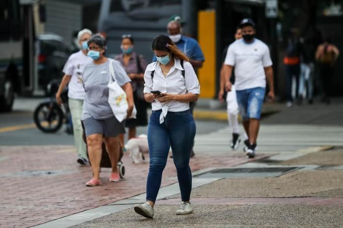 In Caracas benutzt eine Frau ihr Handy, während sie die Straße entlanggeht. Foto: epa/Miguel Gutierrez
