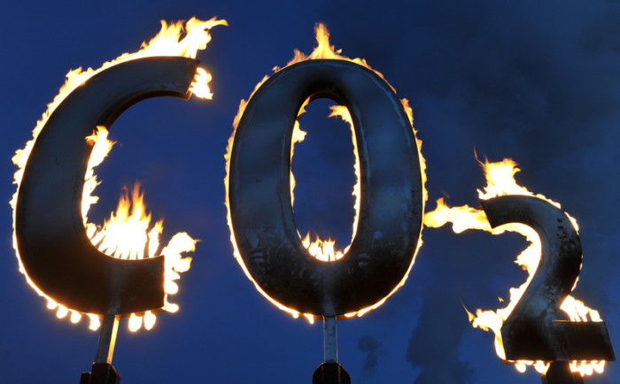 Der mit Gas gespeiste Schriftzug «CO2» brennt nahe dem Kohlekraftwerk Staudinger während einer Aktion der Umweltschutzorganisation Greenpeace. Foto: Uwe Anspach/Dpa