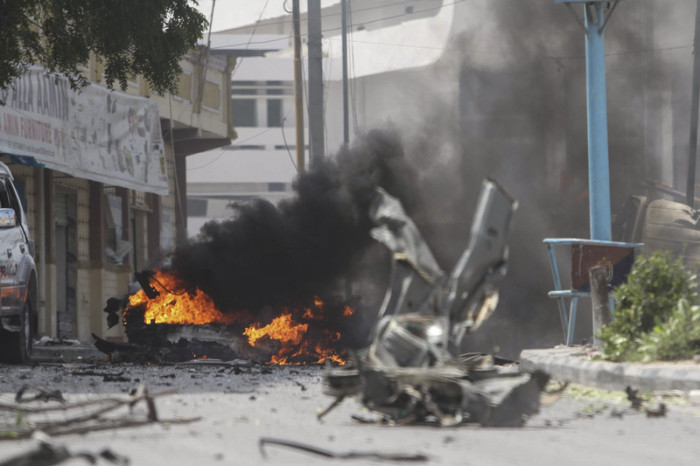 Der Rauch steigt aus einem zerstörten Fahrzeug an der Stelle von Doppelstößen in der Hauptstadt Mogadischu. Foto: epa/Said Yusuf Warsame