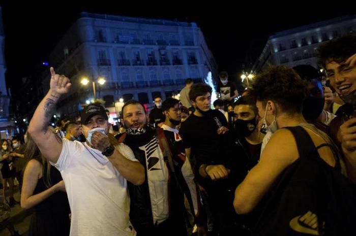 Hunderte von Menschen feiern in Menschen feiern in Madrids Puerta del Sol. Foto: epa/Luca Piergiovanni