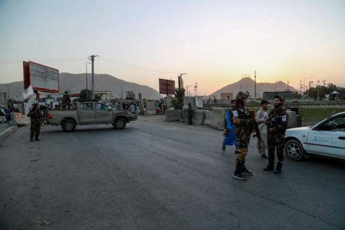 In der Nähe des Tatorts einer Bombenexplosion in Kabul stehen Taliban Wache. Foto: epa/Stringer