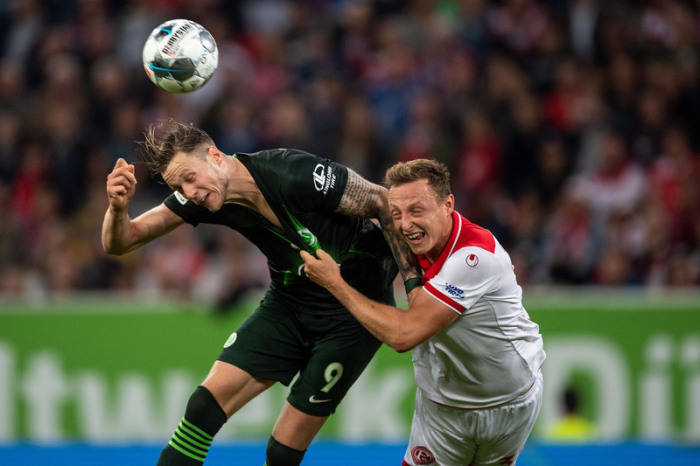 Düsseldorfs Robin Bormuth (r) und Wolfsburgs Wout Weghorst kämpfen um den Ball. Foto: Marius Becker/Dpa