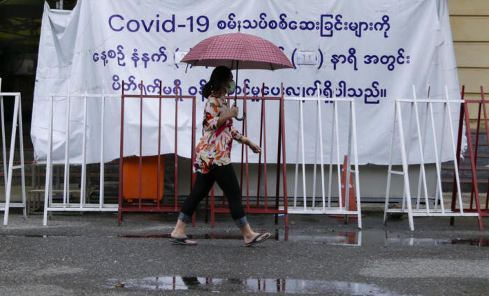 Eine Frau aus Myanmar läuft vor dem COVID-19-Testzentrum in der Innenstadt von Yangon vorbei. Foto: epa/Lynn Bo Bo