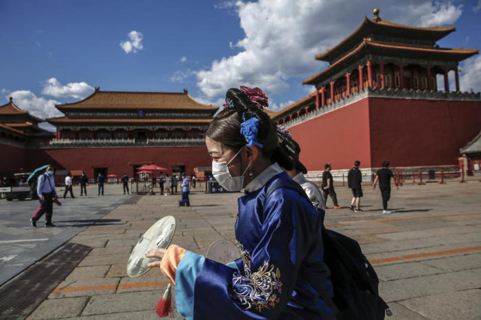 Tradition trifft Gegenwart: Eine Chinesin in traditioneller Tracht trägt eine Gesichtsmaske. Foto: epa/Wu Hong