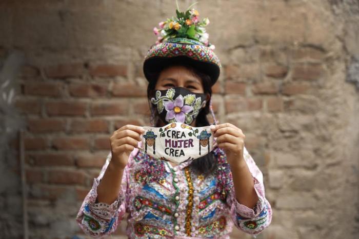 Violeta Quispe Yupari, eine Kunsthandwerkerin aus den peruanischen Anden, zeigt eine Kreation einer Gesichtsmaske, während sie in ihrem Atelier in Lima, Peru, für ein Foto posiert. Foto: epa/Paolo Aguilar