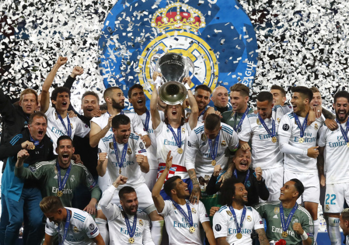Die Spieler von Real Madrid jubeln mit dem Pokal im Konfettiregen. Foto: Matthias Schrader/Ap/dpa 