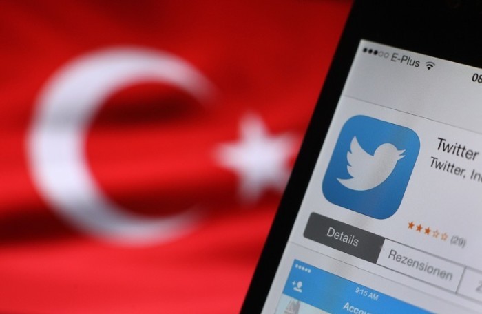 Das Twitter-Logo ist auf einem Smartphone zu sehen, das neben einer türkischen Flagge in Kaufbeuren gehalten wird. Foto: epa/Karl-josef Hildenbrand