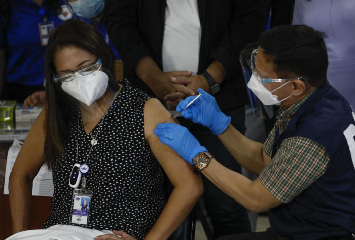 Die Philippinin Eileen Aniceto (L) erhält von dem philippinischen Gesundheitsminister Francisco Duque (R) die erste Dosis des Impfstoffs Sinovac COVID-19. Foto: epa/Rolex Dela Pena