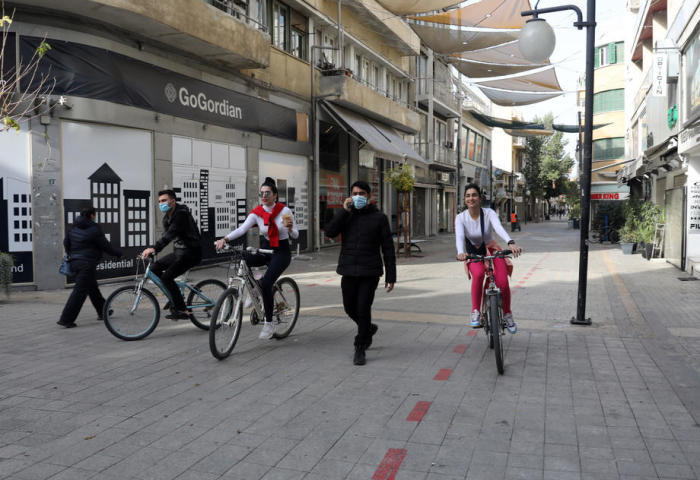 Leute fahren mit ihren Fahrrädern in der Einkaufsstraße von Ledra am ersten Tag der Covid-19-Abriegelung in Nicosia. Foto: epa/Katia Christodoulou