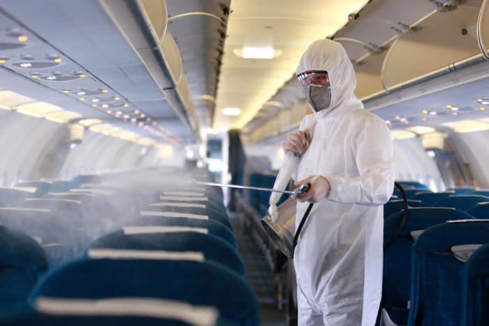 Ein Angestellter sprüht Desinfektionsmittel als Vorsichtsmaßnahme gegen das neuartige Coronavirus im Inneren eines Vietnam Airlines Flugzeugs. Foto: epa/Luong Thai Linh
