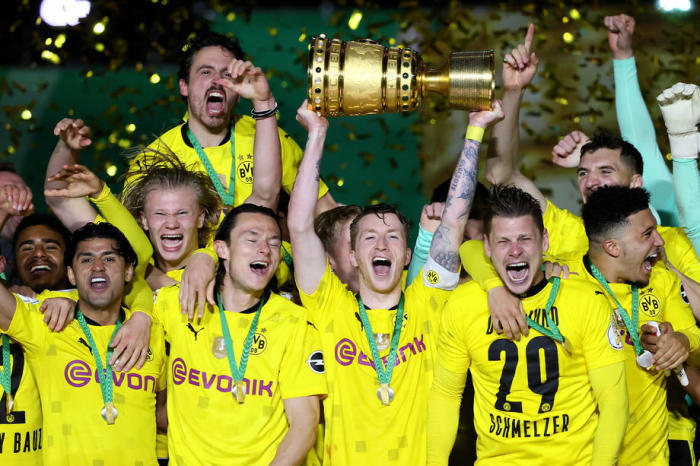 Die Dortmunder Marco Reus (C) hebt den Pokal, während seine Teamkollegen nach dem Sieg im DFB-Pokalfinale zwischen RB Leipzig und Borussia Dortmund in Berlin feiern. Foto: epa/Martin Rose