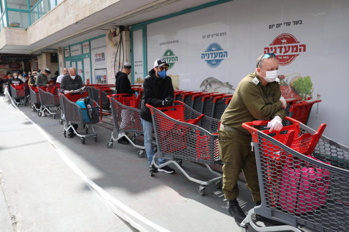 In Jerusalem warten Kunden in einer Schlange vor einem Supermarkt. Foto: epa/Abir Sultan