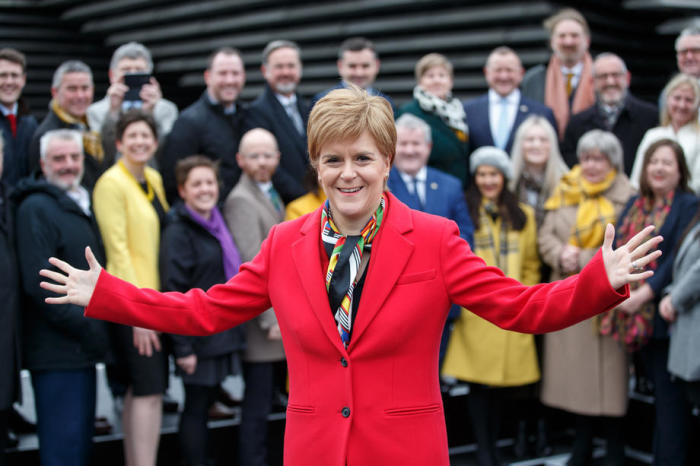 Die SNP-Vorsitzende Nicola Sturgeon stellt sich mit den neu gewählten Abgeordneten der Scottish National Party SNP zu einem Gruppenfoto vor dem V&A Museum in Dundee auf. Foto: epa/Robert Perry