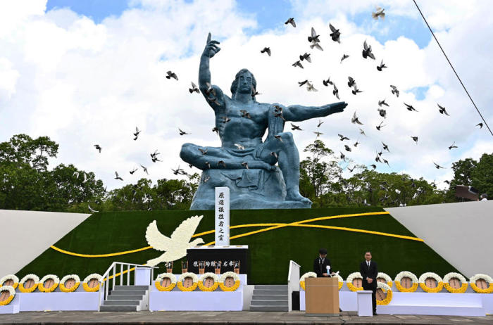 Tauben fliegen während der Gedenkfeier in Nagasaki über die Friedensstatue im Friedenspark von Nagasaki. Foto: epa/Jiji