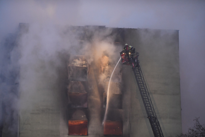 Rauch steigt aus einem Hochhaus auf, während Feuerwehrleute versuchen das Feuer zu löschen. Foto: Frantisek Ivan/Tasr/dpa