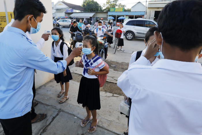 Schüler lassen ihre Temperatur überprüfen, als sie in einer Schule in Phnom Penh ankommen. Foto: epa/Mak Remissa