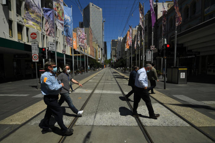 In Melbourne überqueren Menschen die Straße entlang der Bourke Street Mall. Foto: epa/Martin Divisek