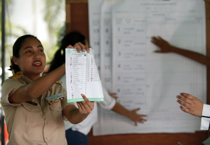 Ein Wahlhelferin hält einen Stimmzettel in der Hand. Foto: epa/Rungroj Yongrit