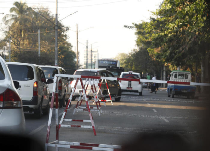 In Yangon fahren Autos durch die Barrikade. Foto: epa/Stringer