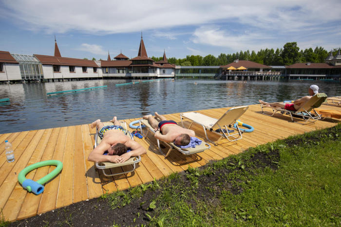 Die Gäste sonnen sich neben dem natürlichen Thermalsee in Heviz. Foto: epa/Gyorgy Varga