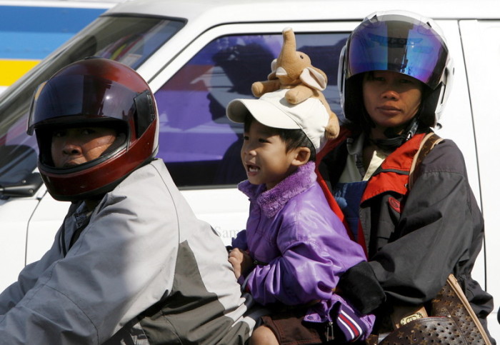 Eine dreiköpfige Familie auf einem Motorrad in Bangkok. Foto: epa/Barbara Walton
