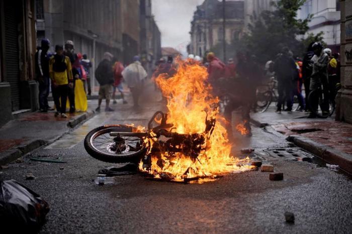 In Bogota wird während eines neuen Tages der Proteste ein Motorrad in Brand gesetzt. Foto: epa/Juan Paez