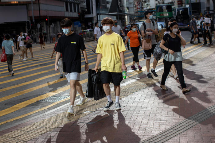 Leute mit Gesichtsmasken überqueren eine Kreuzung in Hongkong. Foto: epa/Jerome Favre