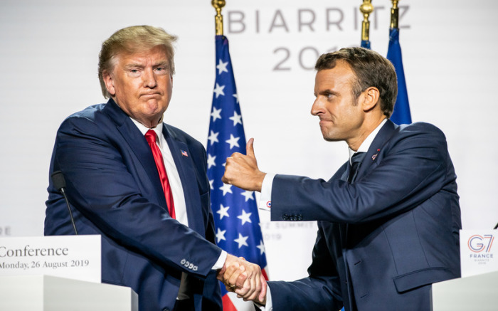 Emmanuel Macron (r), Präsident von Frankreich, reckt den Daumen, und gibt Donald Trump (l), Präsident der USA, während der Abschluss-Pressekonferenz nach dem G7-Gipfel die Hand. Foto: Michael Kappeler/Dpa