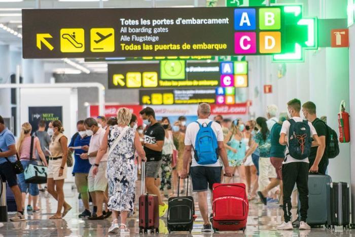 Reisende gehen mit ihrem Gepäck am Flughafen von Palma de Mallorca in Palma, Balearen. Foto: epa/Cati Cladera