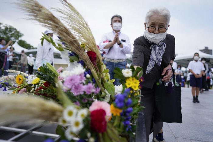 Eine alte Frau bringt eine Blume dar, bevor sie vor einem Kenotaph im Peace Memorial Park in Hiroshima für die Opfer betet. Foto: epa/Dai Kurokawa