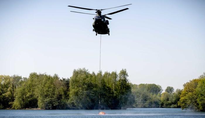 Ein Chinook-Hubschrauber der niederländischen Luftwaffe schöpft Wasser aus dem Effelder Waldsee in Effeld.