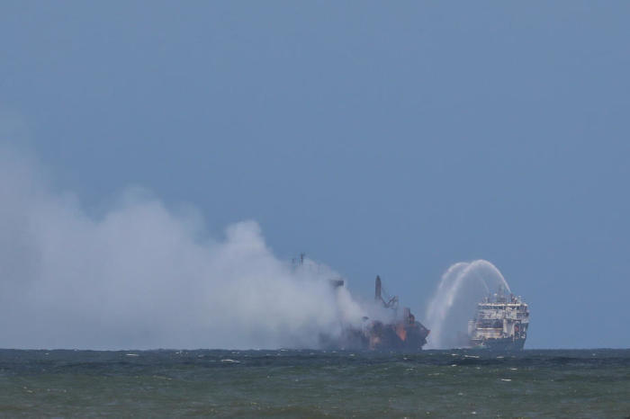 Feuerwehrboote sprühen Wasser auf das brennende Containerschiff. Foto: epa/Chamila Karunarathne