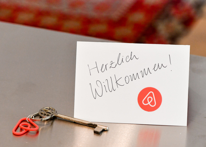 Ein Schlüssel mit einem Airbnb-Anhäger und eine Herzlich-Willkommen-Karte liegen in der Wohnung eines Airbnb-Gastgebers für den Gast bereit. Foto: Jens Kalaene/dpa-Zentralbild/dpa