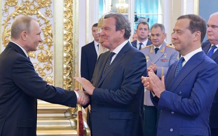 Der russische Präsident Wladimir Putin (L) schüttelt dem ehemaligen deutschen Bundeskanzler Gerhard Schröder (M) die Hand. Foto: epa/Alexei Druzhinin / SPUTNIK / KREMLIN