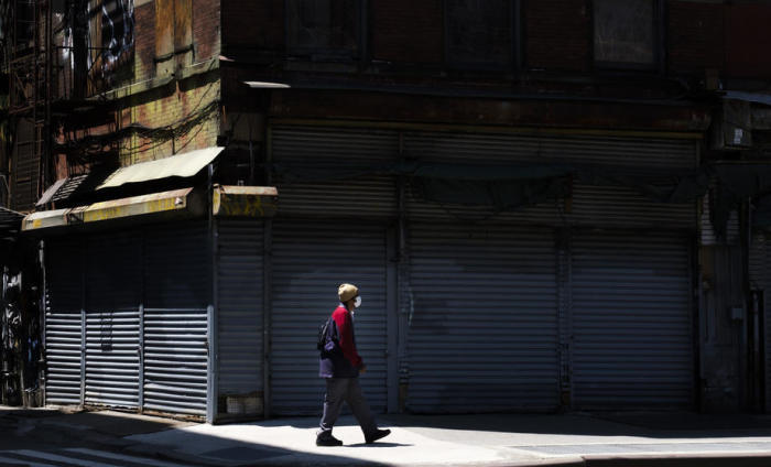 Ein Mann geht an einem geschlossenen Geschäft vorbei. Foto: epa/Justin Lane