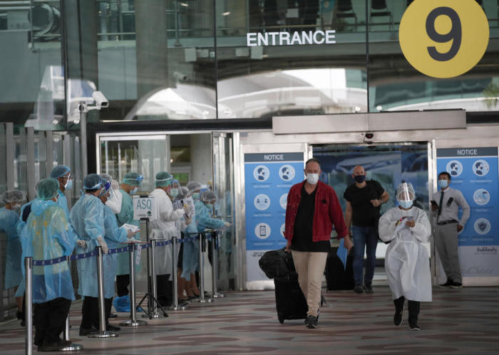 Ein Ausländer wird am internationalen Flughafen in Bangkok vom medizinischen Personal in Empfang genommen. Denn auf die Landung folgt die Quarantäne. Foto: epa/Rungroj Yongrit