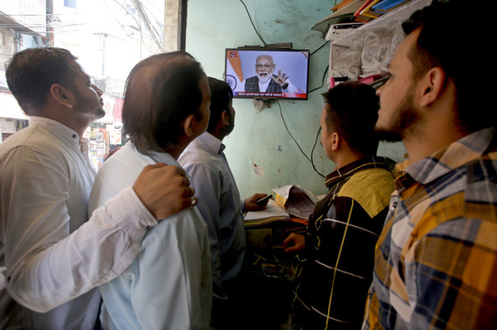 Inder verfolgen die Rede des indischen Premierminister Narendra Modi. Foto: epa/Jaipal Singh
